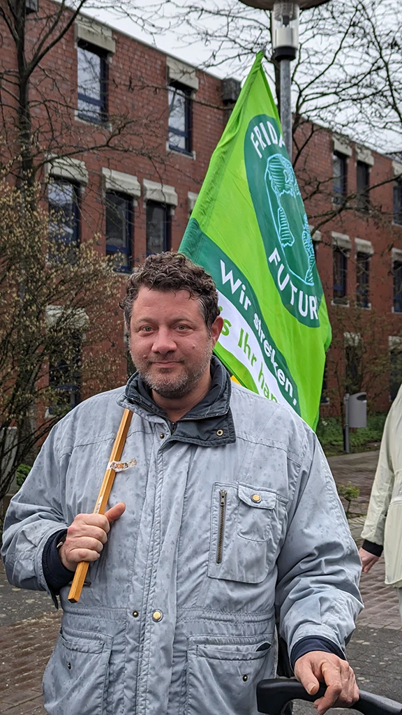 Ein Mann trägt die Fahne von Fridays For Future