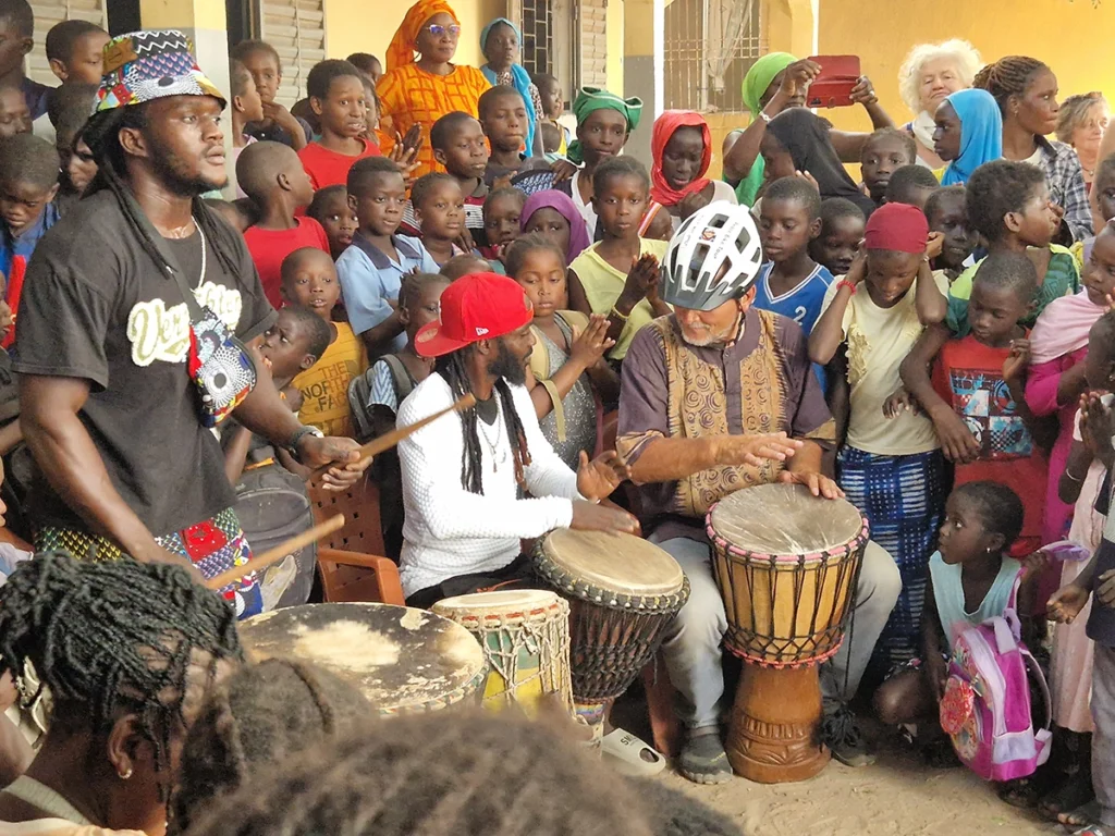 Christoph Roller an der Trommel umringt von Kindern und Erwachsenen