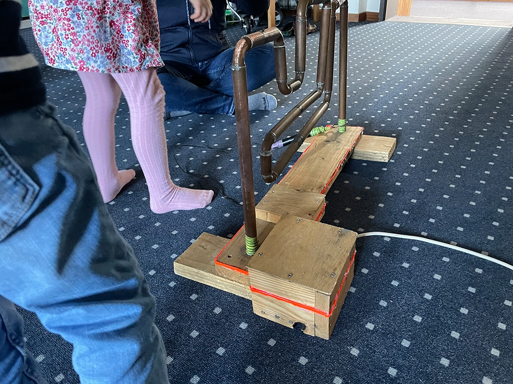 Ein Kind steht vor einem Hindernis aus Rohren.