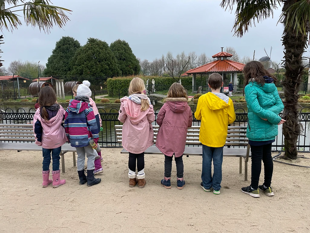 Kinder am Geländer vor dem Teich.