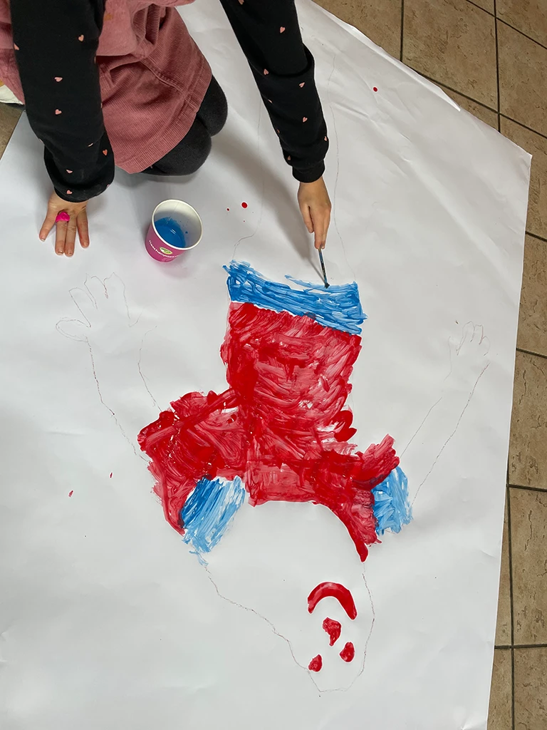 Kind malt auf dem Boden einen Geist.