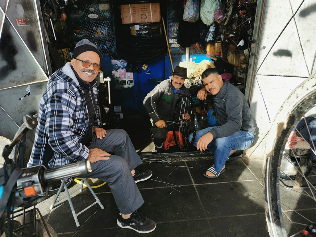 Drei Männer sitzen im Fahrradladen.