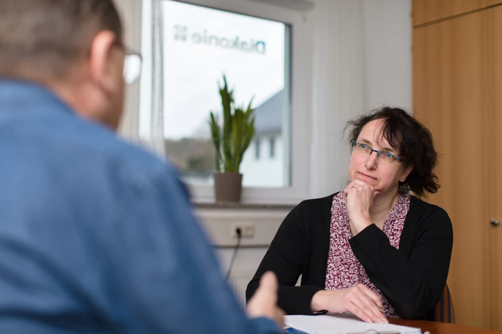 Eine Frau hört einem Mann aufmerksam zu.